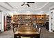 Library with a large table, comfortable seating, and floor-to-ceiling bookshelves filled with a wide selection of books at 1046 Almondwood Dr, Trinity, FL 34655