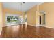 Bright living room featuring a hardwood floor and a view of the backyard and an entrance to the kitchen at 1046 Almondwood Dr, Trinity, FL 34655