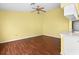Bright, open living space with wood floors, ceiling fan, and adjacent kitchen area at 1046 Almondwood Dr, Trinity, FL 34655