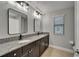 Bathroom featuring double sinks, granite countertops, modern fixtures, and a window for natural light at 11804 Harpswell Dr, Riverview, FL 33579