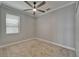 Carpeted bedroom with a ceiling fan, large window, neutral colors, and a double closet at 11804 Harpswell Dr, Riverview, FL 33579