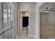 Hallway features access to bedroom with ceiling fan and an enclosed shower and commode at 11804 Harpswell Dr, Riverview, FL 33579