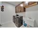 Laundry room has washer, dryer, utility sink, tile flooring and storage cabinets above at 11804 Harpswell Dr, Riverview, FL 33579