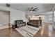 Spacious living room features hardwood floors, modern ceiling fan, and a view into the kitchen at 11804 Harpswell Dr, Riverview, FL 33579