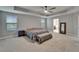 Spacious main bedroom with neutral tones, ceiling fan and natural light; ensuite bathroom at 11804 Harpswell Dr, Riverview, FL 33579