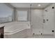 Bright, spacious main bathroom featuring soaking tub and frameless glass enclosed shower with luxurious marble surround at 11804 Harpswell Dr, Riverview, FL 33579