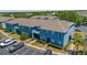 Daytime aerial view of blue townhouses with parking and landscaping at 12805 Kings Crossing Dr, Gibsonton, FL 33534