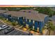 Stunning aerial view of blue townhouses at sunset with parking and landscaping at 12805 Kings Crossing Dr, Gibsonton, FL 33534