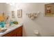 Well-lit bathroom featuring decorative elements, framed artwork, and neutral color scheme at 12805 Kings Crossing Dr, Gibsonton, FL 33534