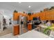 Kitchen with stainless steel appliances, oak cabinets, and modern lighting fixtures at 12805 Kings Crossing Dr, Gibsonton, FL 33534