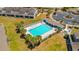 Aerial view of a community pool, surrounded by lounge chairs, palm trees, and a white fence at 12805 Kings Crossing Dr, Gibsonton, FL 33534