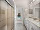 Bathroom with double sink vanity, shower, and view of pool at 12902 Grand Traverse Dr, Dade City, FL 33525