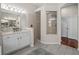 Spacious bathroom featuring a glass shower, double sinks, and tile floor at 12902 Grand Traverse Dr, Dade City, FL 33525