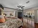 Bedroom with hardwood floors, a ceiling fan and a view of the pool area at 12902 Grand Traverse Dr, Dade City, FL 33525