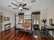 Spacious bedroom featuring a four-poster bed, a ceiling fan, and hardwood floors at 12902 Grand Traverse Dr, Dade City, FL 33525