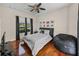 Comfortable bedroom features a queen bed, ceiling fan, and view of the front yard at 12902 Grand Traverse Dr, Dade City, FL 33525