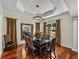 Elegant dining room featuring hardwood floors, large mirror, coffered ceiling, and a stylish chandelier at 12902 Grand Traverse Dr, Dade City, FL 33525
