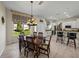 Bright dining area featuring pendant lighting, and views of the green outdoors, blending elegance and nature at 12902 Grand Traverse Dr, Dade City, FL 33525