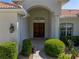 Elegant front entrance featuring double doors, manicured shrubs, and a well-maintained walkway at 12902 Grand Traverse Dr, Dade City, FL 33525