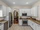 Well-equipped kitchen features stainless steel appliances, white cabinetry, and an open view to the dining area at 12902 Grand Traverse Dr, Dade City, FL 33525