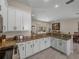 Bright kitchen featuring granite counters, stainless steel appliances, and ample cabinetry for storage and meal prep at 12902 Grand Traverse Dr, Dade City, FL 33525