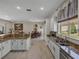 Open kitchen features granite counters, stainless appliances, and natural light with a view of the dining and living spaces at 12902 Grand Traverse Dr, Dade City, FL 33525