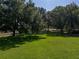 Expansive green lawn area shaded by mature trees, showcasing a beautiful and serene outdoor setting at 12902 Grand Traverse Dr, Dade City, FL 33525