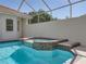 Screened-in pool and integrated spa featuring tile accents create a relaxing outdoor space at 12902 Grand Traverse Dr, Dade City, FL 33525