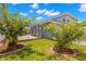 Spacious backyard featuring lush green grass, decorative trees, and access to the screened-in pool area at 12925 Tar Flower Dr, Tampa, FL 33626