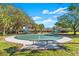 Community basketball court with green painted surface, bench, and playground in background at 12925 Tar Flower Dr, Tampa, FL 33626