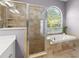 Bathroom boasts walk-in shower and a soaking tub near the window at 12925 Tar Flower Dr, Tampa, FL 33626