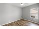 Bright bedroom features a ceiling fan, window, and beautiful wood-look flooring at 12925 Tar Flower Dr, Tampa, FL 33626