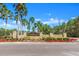 View of Westwood Lakes entrance sign surrounded by lush landscaping and mature palm trees under a bright blue sky at 12925 Tar Flower Dr, Tampa, FL 33626