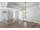 Bright living room featuring tray ceilings, hardwood floors, and modern chandelier at 12925 Tar Flower Dr, Tampa, FL 33626