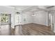 Open-concept living room with tray ceilings, hardwood floors, arched entryway, and lots of natural light at 12925 Tar Flower Dr, Tampa, FL 33626