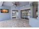 Covered patio featuring stone flooring, ceiling fan, and sliding glass doors to pool at 12925 Tar Flower Dr, Tampa, FL 33626