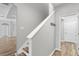 Modern staircase with white banister and wood-look flooring leads to upper level at 12925 Tar Flower Dr, Tampa, FL 33626