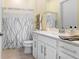 Clean bathroom with white vanity and a white and gray patterned shower curtain at 14184 Samoa Hill Ct, Riverview, FL 33569