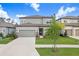 Two-story home featuring a well-manicured lawn, a gray garage door, and a gray and white color scheme at 14184 Samoa Hill Ct, Riverview, FL 33569