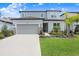 Two-story home showcasing a gray garage door, white accents, and manicured green lawn at 14184 Samoa Hill Ct, Riverview, FL 33569