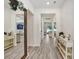 Bright foyer with white walls, wood-look floors, and a large mirror reflecting the open-concept living area at 14184 Samoa Hill Ct, Riverview, FL 33569