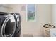 Laundry room with modern front-load washer and dryer and a window for natural light at 14184 Samoa Hill Ct, Riverview, FL 33569