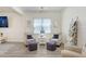 Comfortable living room featuring stylish chairs, ottomans, and wood-look flooring at 14184 Samoa Hill Ct, Riverview, FL 33569
