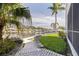 Waterfront backyard with lush lawn, brick pavers, canal access, and tropical palm trees at 1625 Watermark Ne Cir, St Petersburg, FL 33702