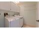 Laundry room with appliances, storage cabinets, and ample shelf space for organizing essentials at 1625 Watermark Ne Cir, St Petersburg, FL 33702