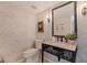 Stylish powder room with a decorative mirror, patterned walls, tiled floor and designer touches at 1625 Watermark Ne Cir, St Petersburg, FL 33702