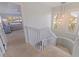 Carpeted staircase landing with windows and view to a bedroom at 1625 Watermark Ne Cir, St Petersburg, FL 33702