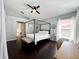Primary bedroom features a canopy bed, dark wood floors, and a ceiling fan at 1813 Landside Dr, Valrico, FL 33594