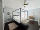 Bedroom features a canopy bed, dark wood floors, and a ceiling fan at 1813 Landside Dr, Valrico, FL 33594