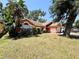 Landscaped front yard with lush green grass and mature trees enhances the appeal of this lovely home at 1813 Landside Dr, Valrico, FL 33594